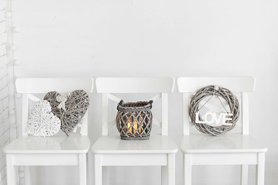 gray wicker wreath and candle holder on top of three white wooden chairs HD wallpaper