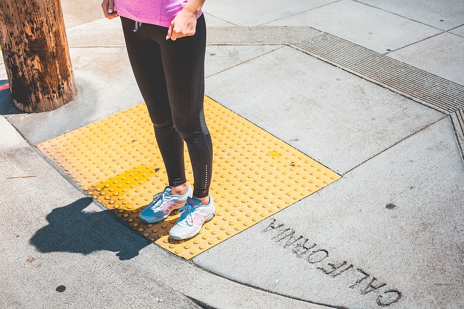 Young Female Jogger Waiting at the Edge of a Zebra Crossing, active HD wallpaper