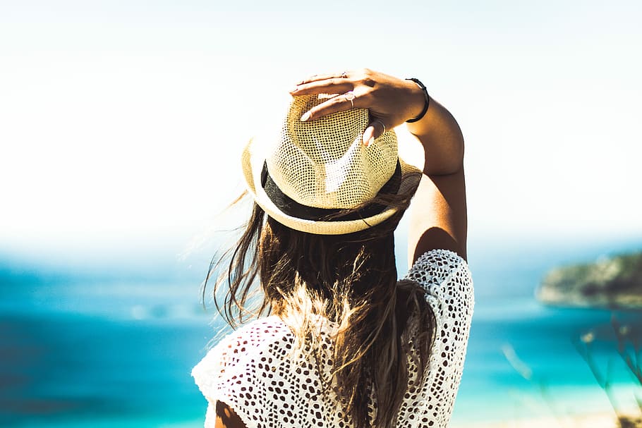 woman holding on to her hat, women standing holding hat facing sea HD wallpaper