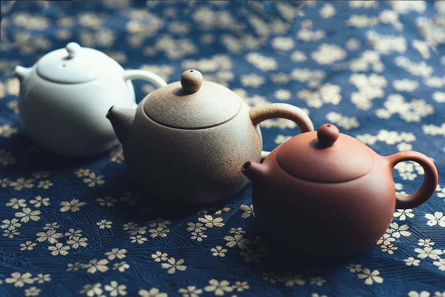 three assorted-color teapots, shallow focus photography of brown, beige, and white ceramic teapots HD wallpaper