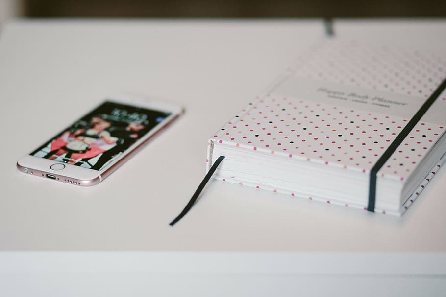 gold iPhone 6 beside notebook on white table, rose, hardbound HD wallpaper