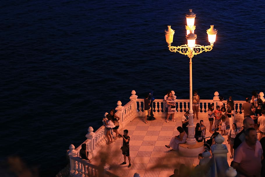 people standing on balcony during night, group of people standing on balcony across body of water HD wallpaper