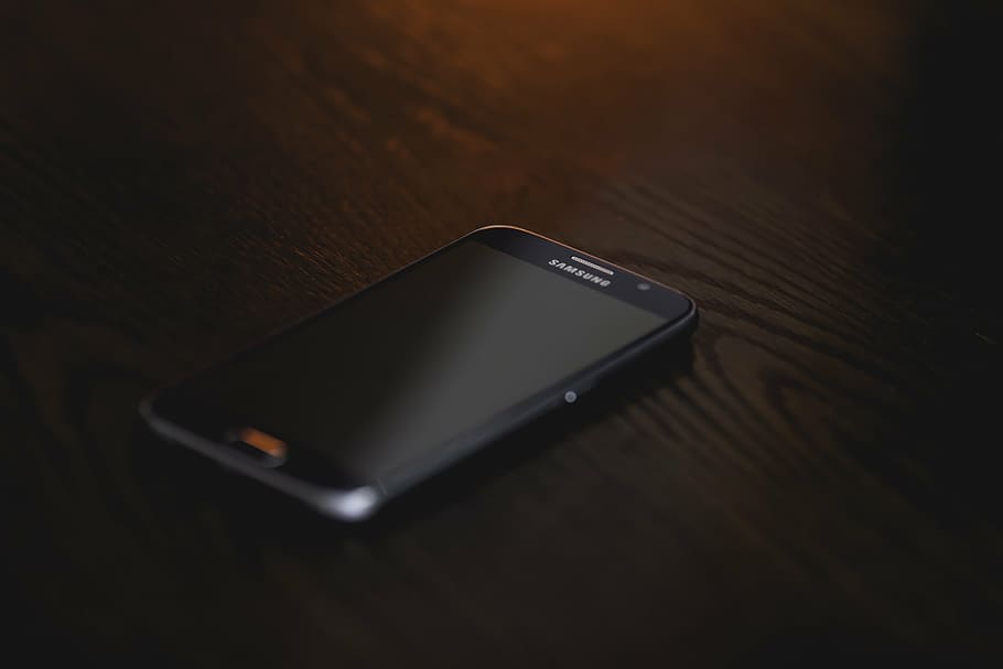 black Samsung smartphone on wooden surface, dark, technology HD wallpaper