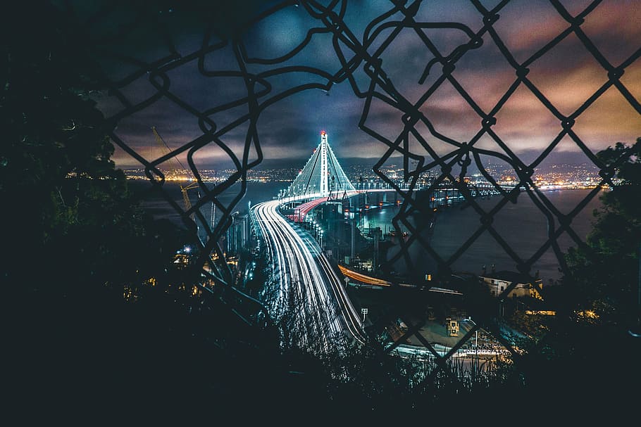 link fence facing lighted city bridge, black, steel, night HD wallpaper