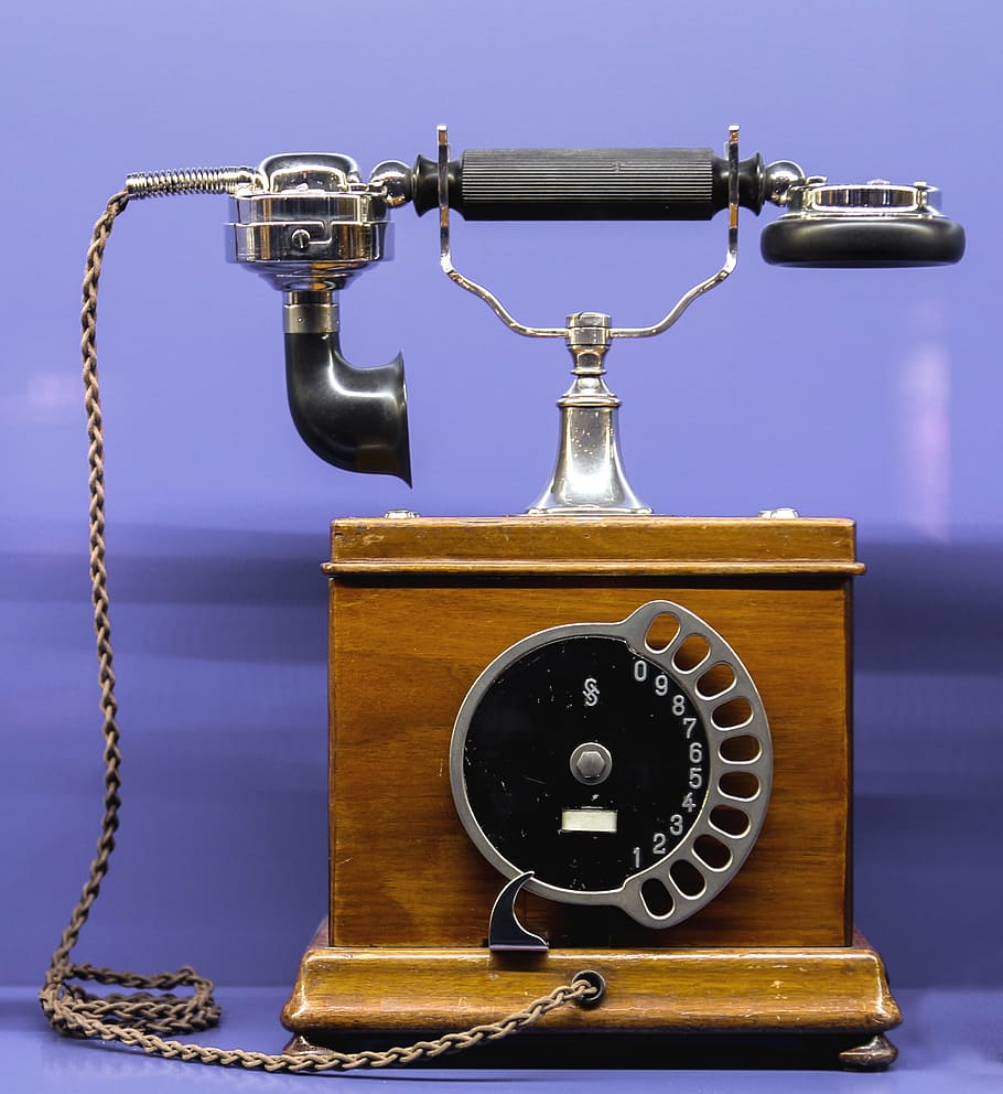 close-up photography of gray and brown cradle home phone, communication