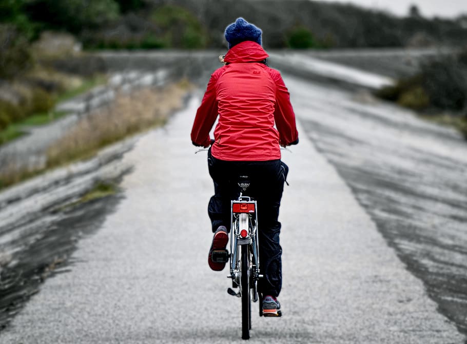 shallow focus photography of person cycling on road, north sea