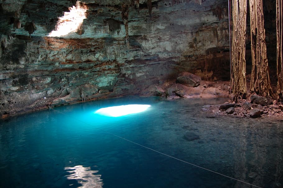 people standing inside cavern with water, cenote, majestic, yucatan