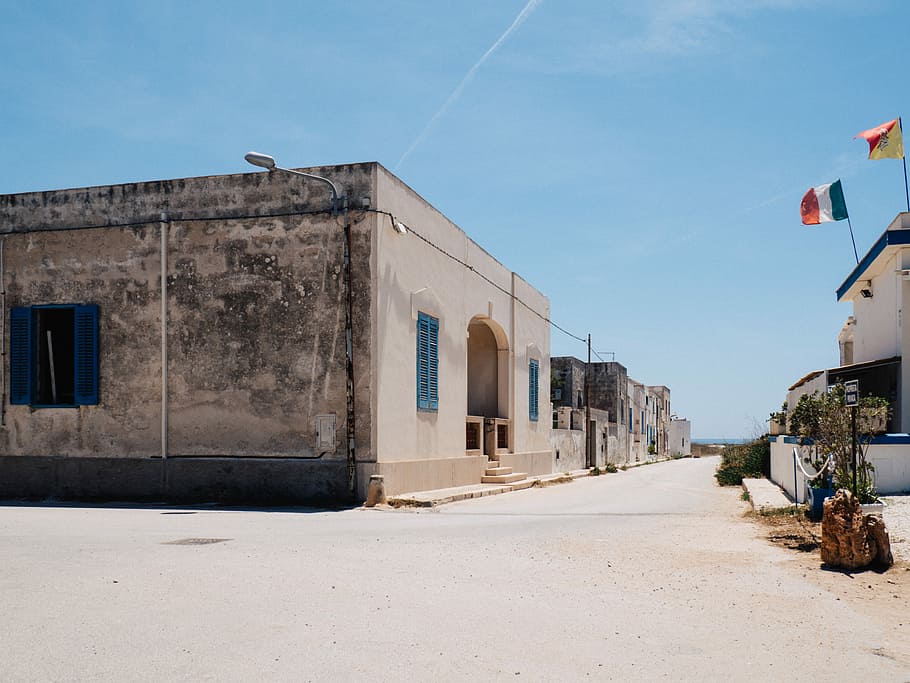 grey and white concrete house, brown concrete building near light post under blue sky HD wallpaper