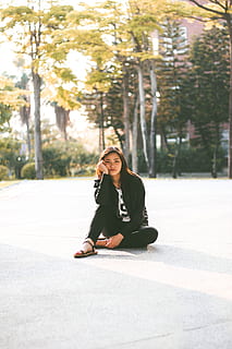 woman in black jacket while sitting on floor, woman sitting on gray pavement HD wallpaper