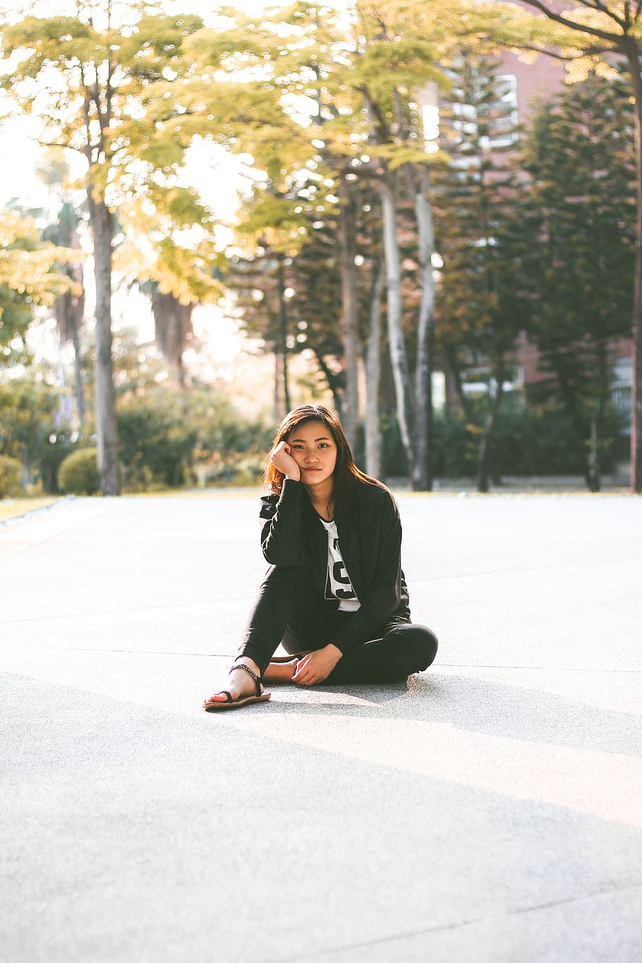 woman in black jacket while sitting on floor, woman sitting on gray pavement HD wallpaper