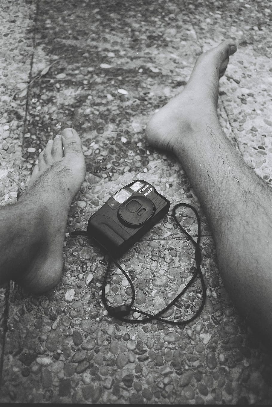 camera in the middle of persons feet, grayscale photography of person on tiled surface in front Canon camera HD wallpaper