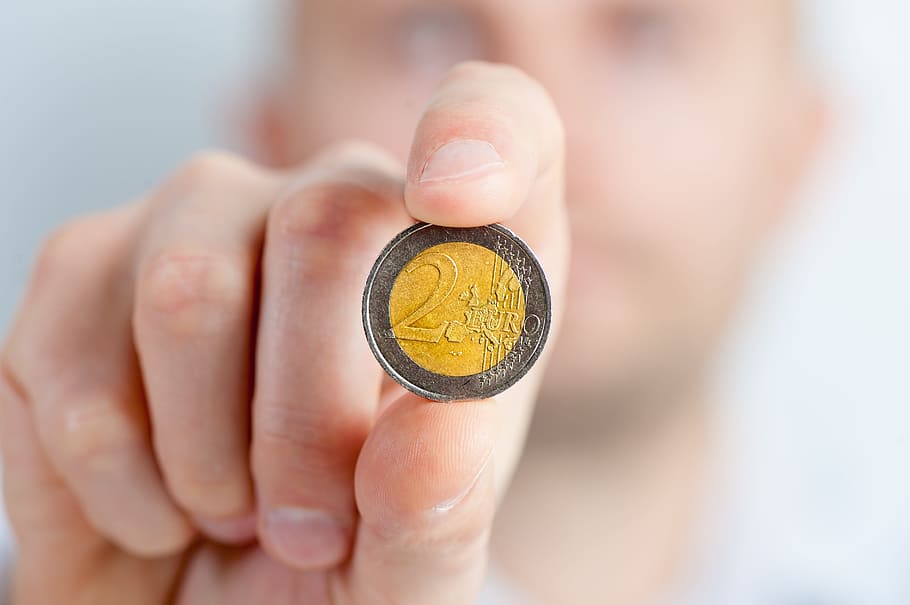 person holding round silver and gold-colored 2 coin, coins, money, HD wallpaper