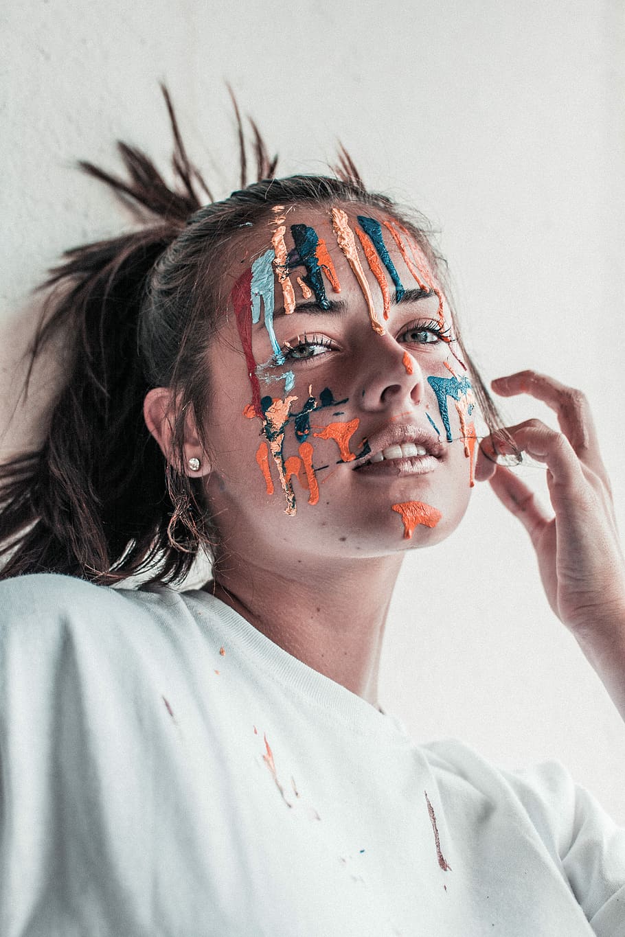 woman leaning on wall with paint on face, woman face splattered with painting HD wallpaper