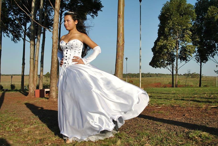 woman in white sweetheart satin gown, posing, against the wind