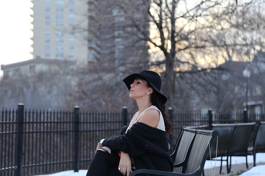 woman in white sleeveless dress and black top with hat sitting during daytime HD wallpaper