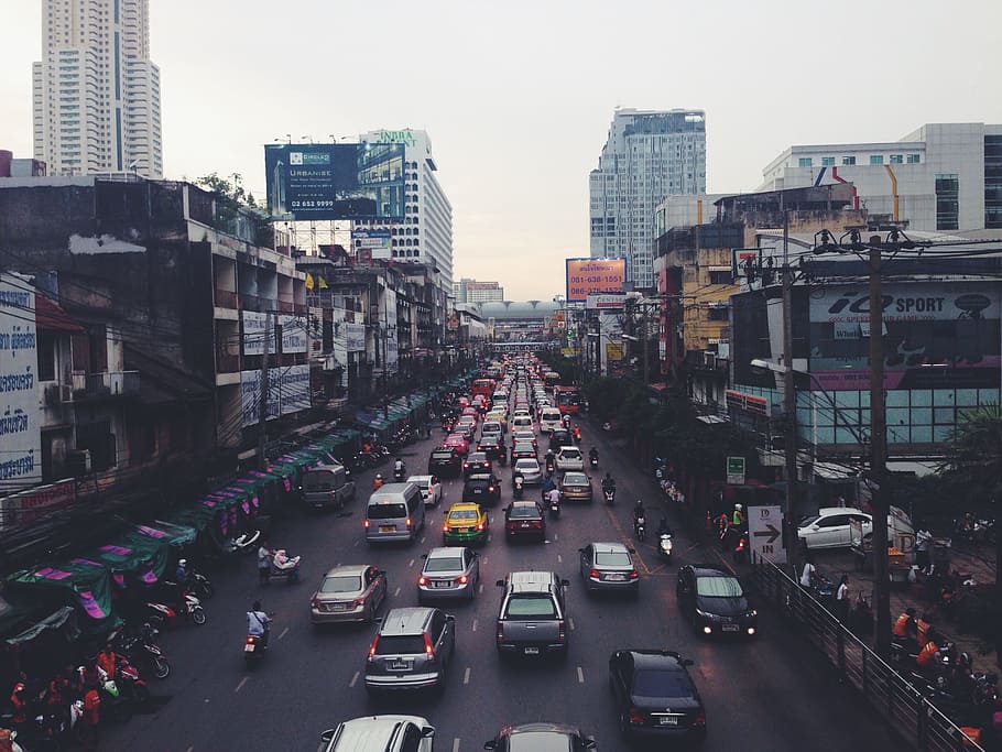 assorted cars on asphalt road beside buildings, aerial photography of vehicles on road near buildings under white sky at daytime HD wallpaper