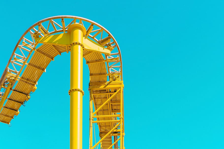 yellow metal roller coaster track under blue sky at daytime HD wallpaper