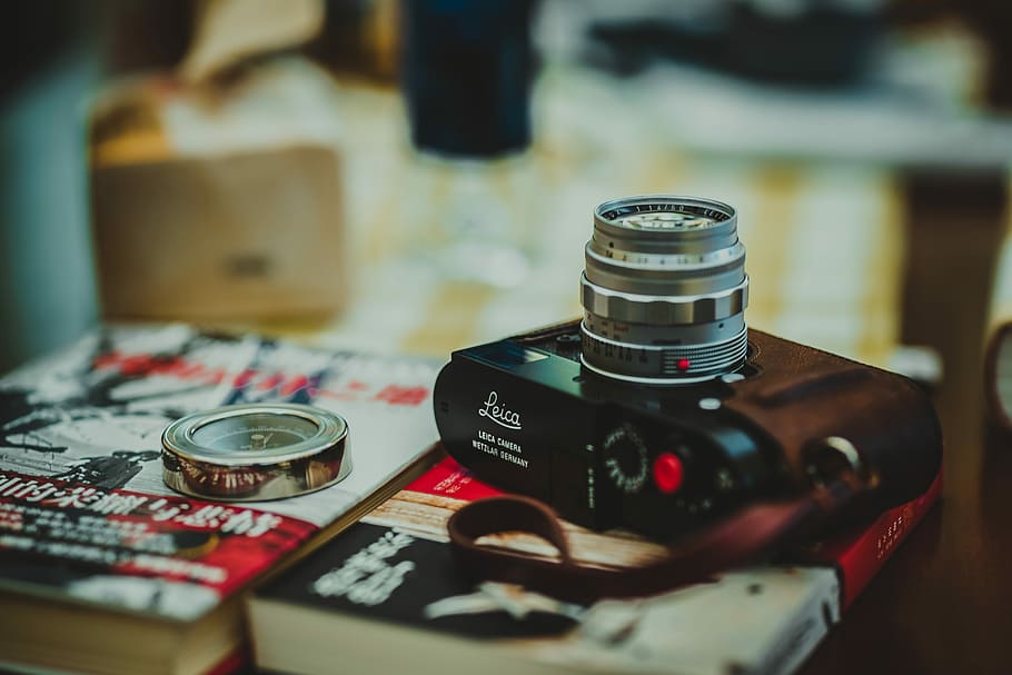 black digital camera on red book, selective photography of black compact camera near silver-colored ring HD wallpaper