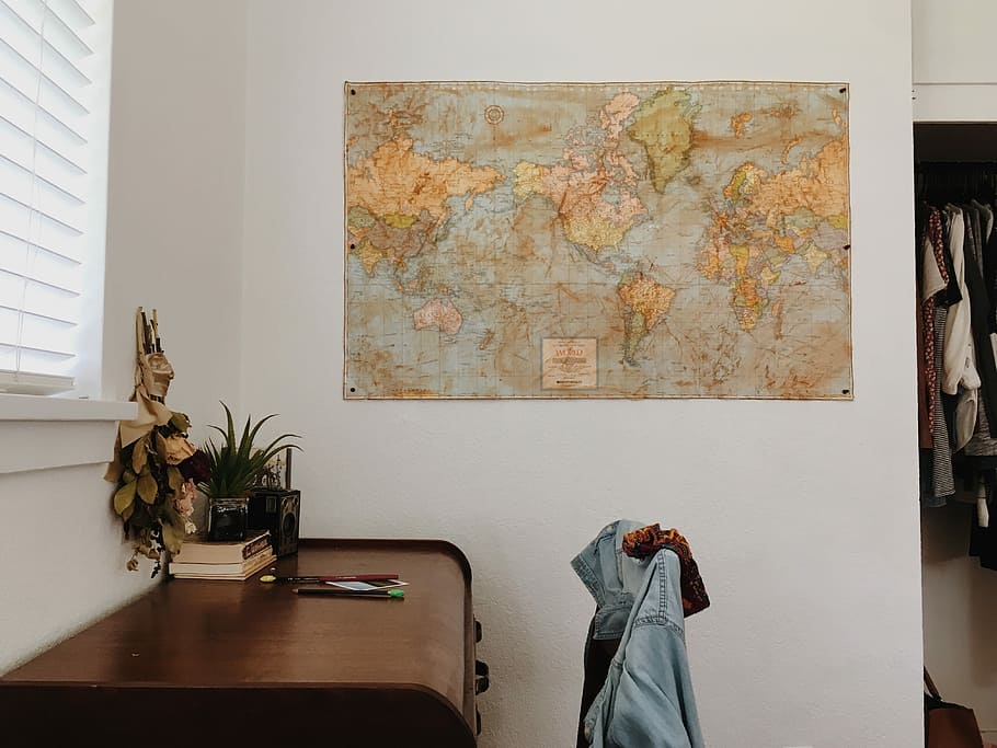 world map placing on wall near brown wooden desk, brown world map mounted on wall HD wallpaper