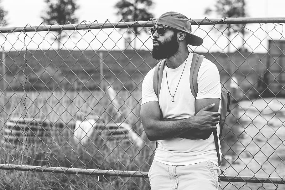 man leaning on chain link fence, guy, beard, sunglasses, hat HD wallpaper