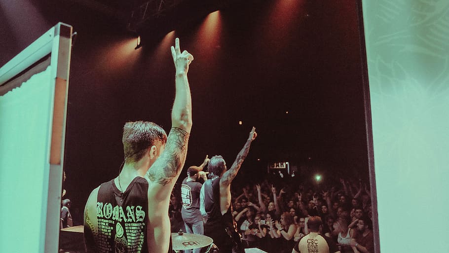 man wearing black sleeveless shirt with tattoo's on the concert, man raising hands on stage HD wallpaper