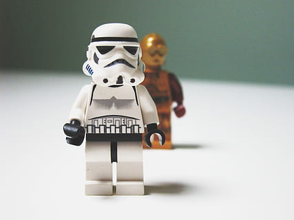 Lego Star Wars C3-P0 behind Stormtrooper toys, Lego Star Wars Storm Trooper minifig on white surface HD wallpaper