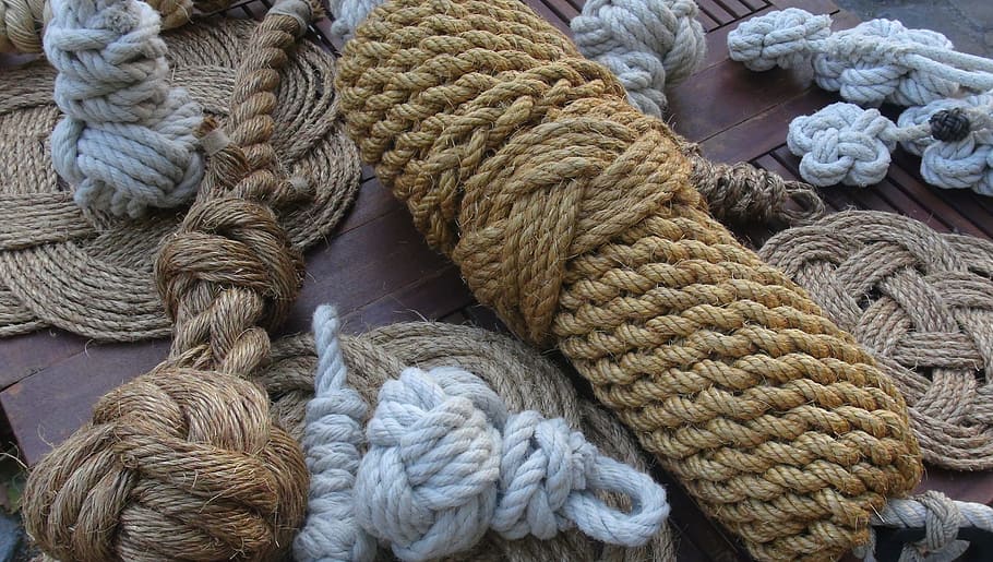 several assorted-color rolled hemp ropes on wooden surface, node