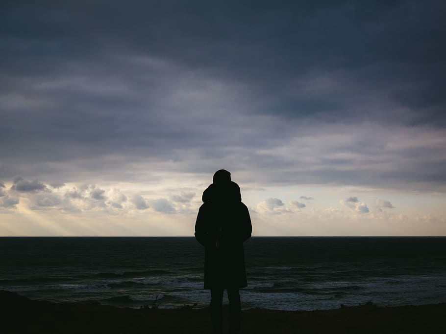 silhouette of man standing on plains under cloudy sky during daytime, silhouette photo of person facing the horizon HD wallpaper