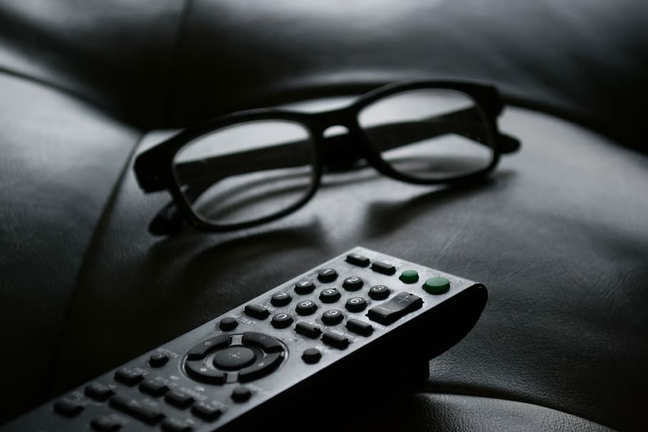 grayscale photo of remote beside eyeglasses, shallow focus photography of eyeglasses near remote HD wallpaper