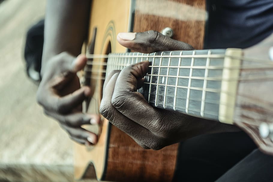 person holding brown and black dreadnought acoustic guitar, musician
