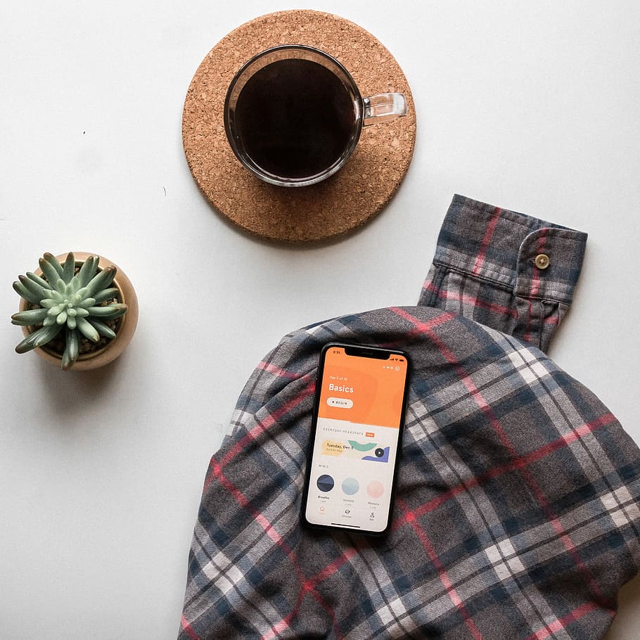 black smartphone on long-sleeved shirt, flat-lay photo of space gray iPhone x, coffee on brown coaster HD wallpaper
