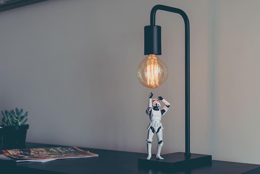 Storm Trooper vinyl figure under desk lamp, Star Wars Stormtrooper action figure on black tube lamp