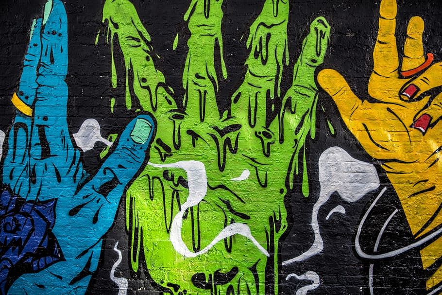 Street art depicting vibrantly coloured hands captured on a brick wall, HD wallpaper