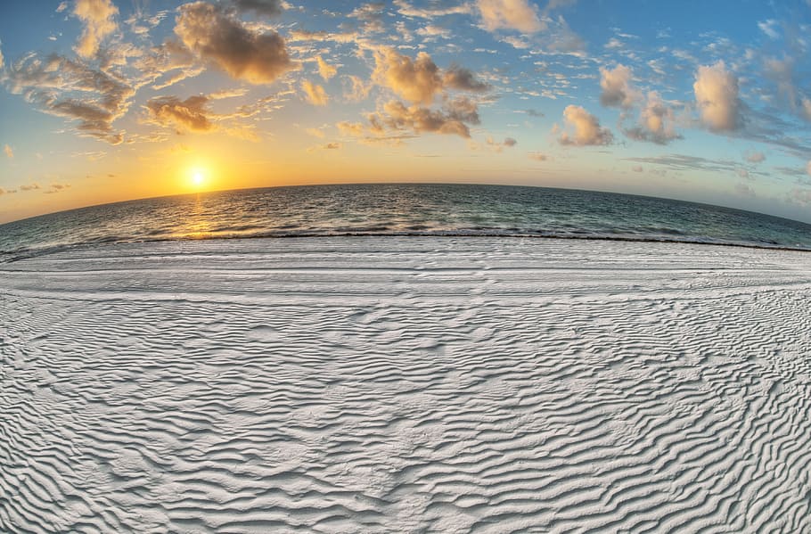 gray sand near body of water under white and blue sky at sunrise, wide angle photo of shoreline during golden hour HD wallpaper