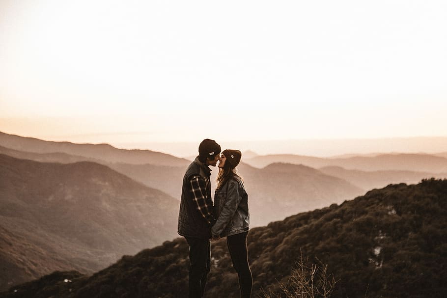 man and woman kissing on mountain during daytime, man and woman kissing on mountain range top HD wallpaper