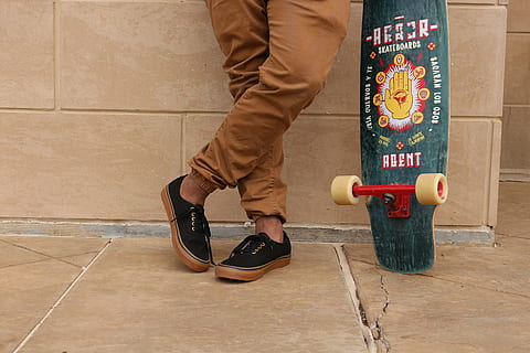 man holding longboard leaning on wall, person, wearing, brown HD wallpaper