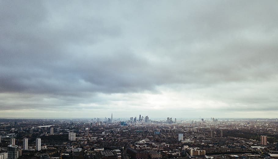 aerial photo of city during cloudy day, gray clouds over city buildings HD wallpaper