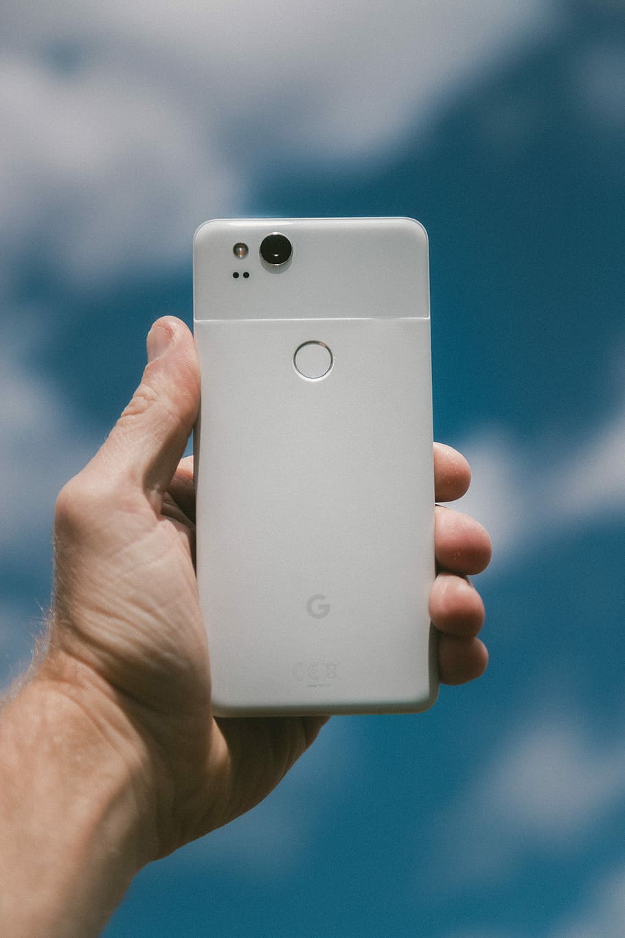 person holding white Google Android smartphone, person holding very silver Google Pixel XL smartphone