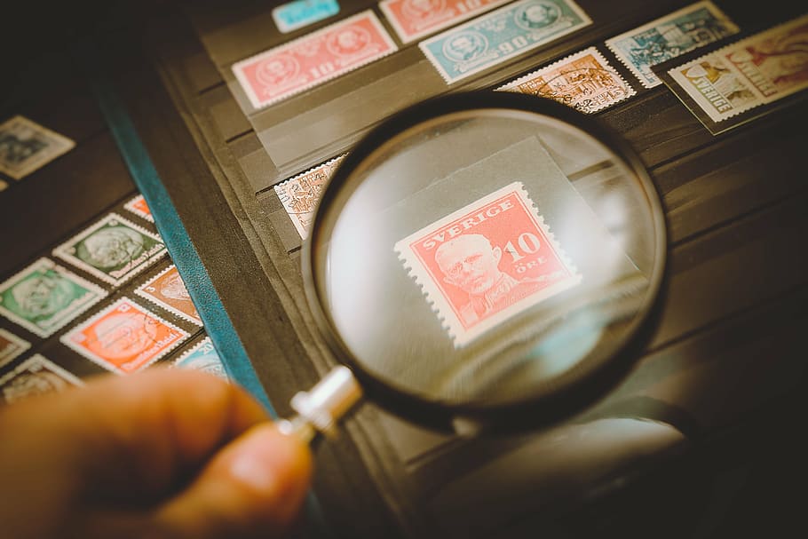magnifying glass showing postage stamp, philatelist, stamp collection
