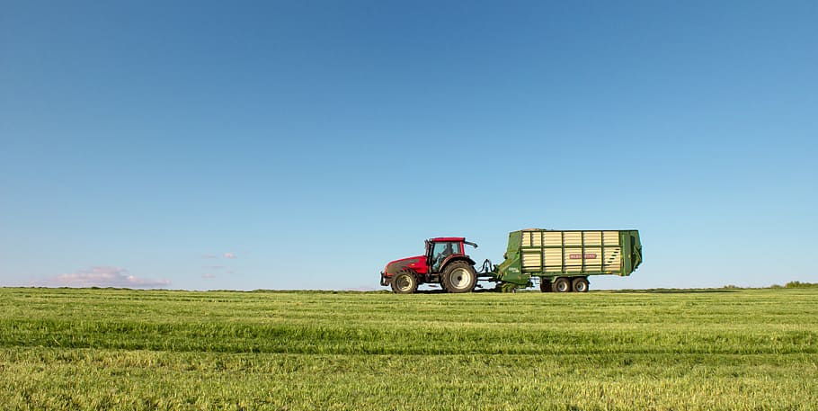 HD wallpaper: red tractor with green trailer on wide grass field