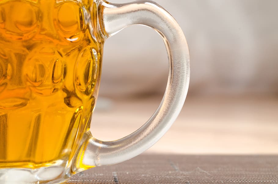 clear glass beer mug labeled with beer on brown wooden surface
