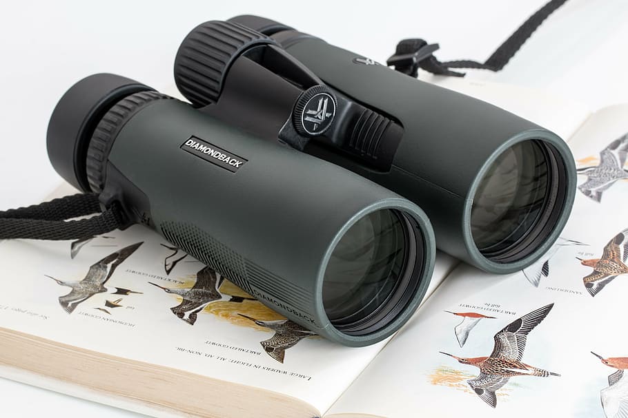 black range finder on top of book, binoculars, birdwatching, spy glass