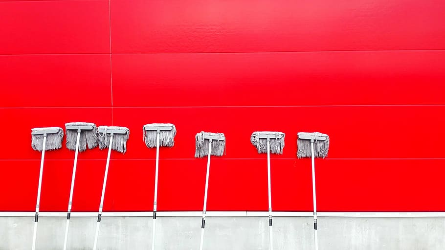 seven white push mops on wall, seven gray mops leaning at red wall HD wallpaper
