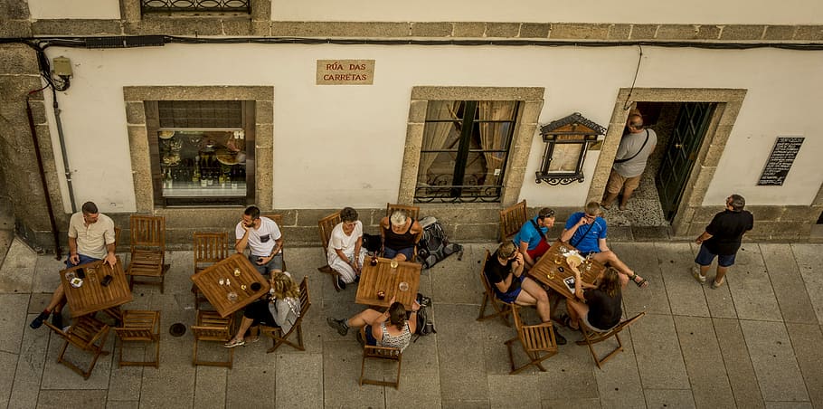 Taking av break, aerial photo of group of people sitting on chairs with tables beside white concrete building HD wallpaper