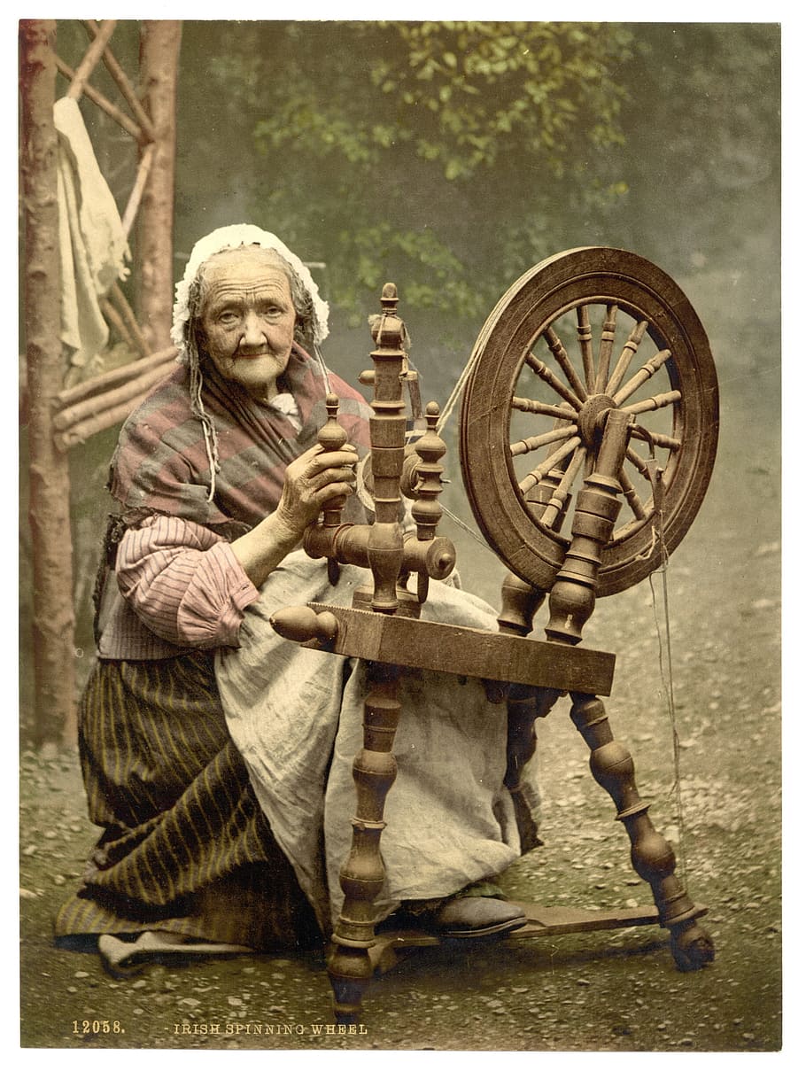 woman sitting on chair holding spinning wheel, spinner, irish spinner