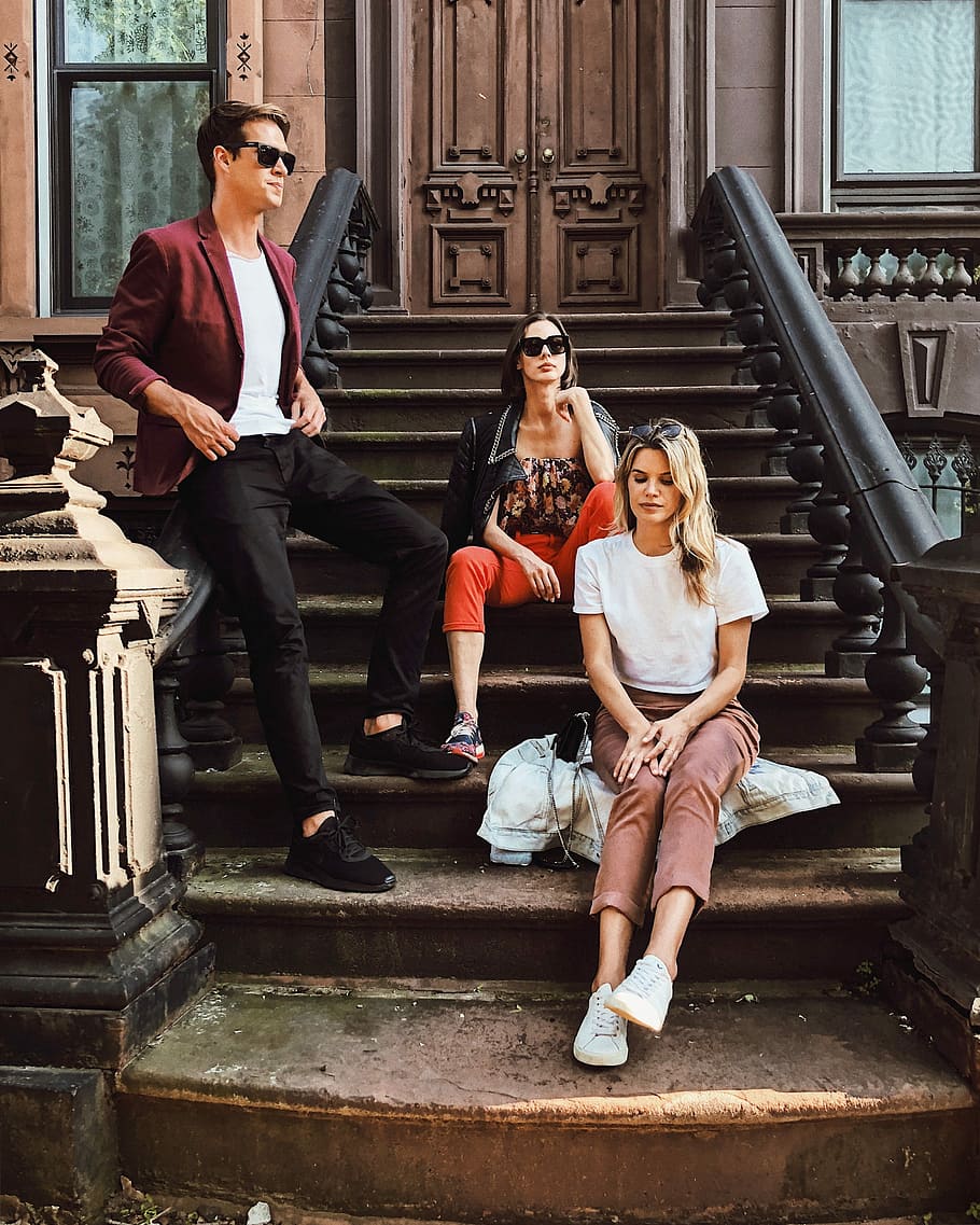 two women sitting and man standing on stair, two women and one man sitting on the stairs HD wallpaper