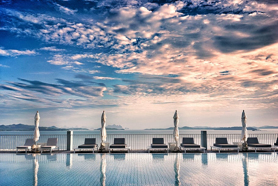loungers near pool under gray clouds, sun loungers near swimming pool HD wallpaper