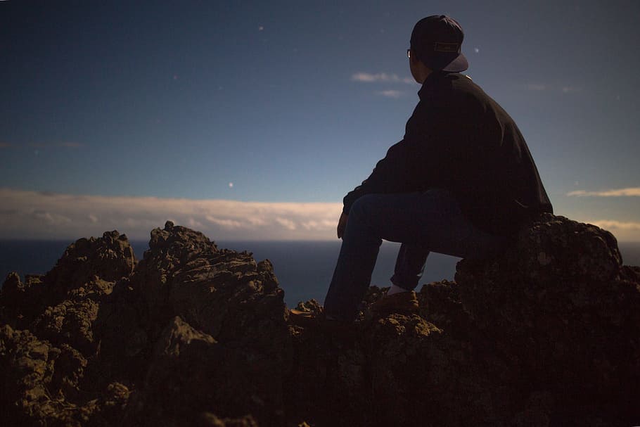 person sitting on rock looking at sky, person sitting on big rock looking at the sky HD wallpaper