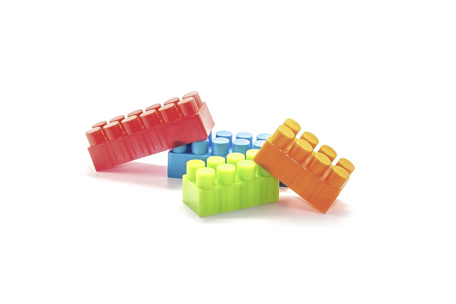 four assorted-color interlocking brick toys on white background HD wallpaper