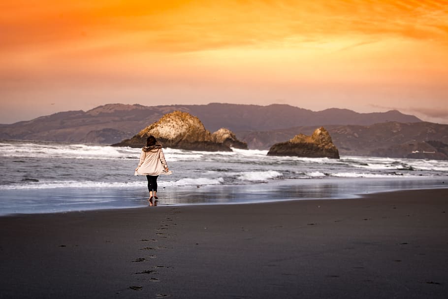woman wearing on seashore during sunset, woman walking near sea during daytime HD wallpaper